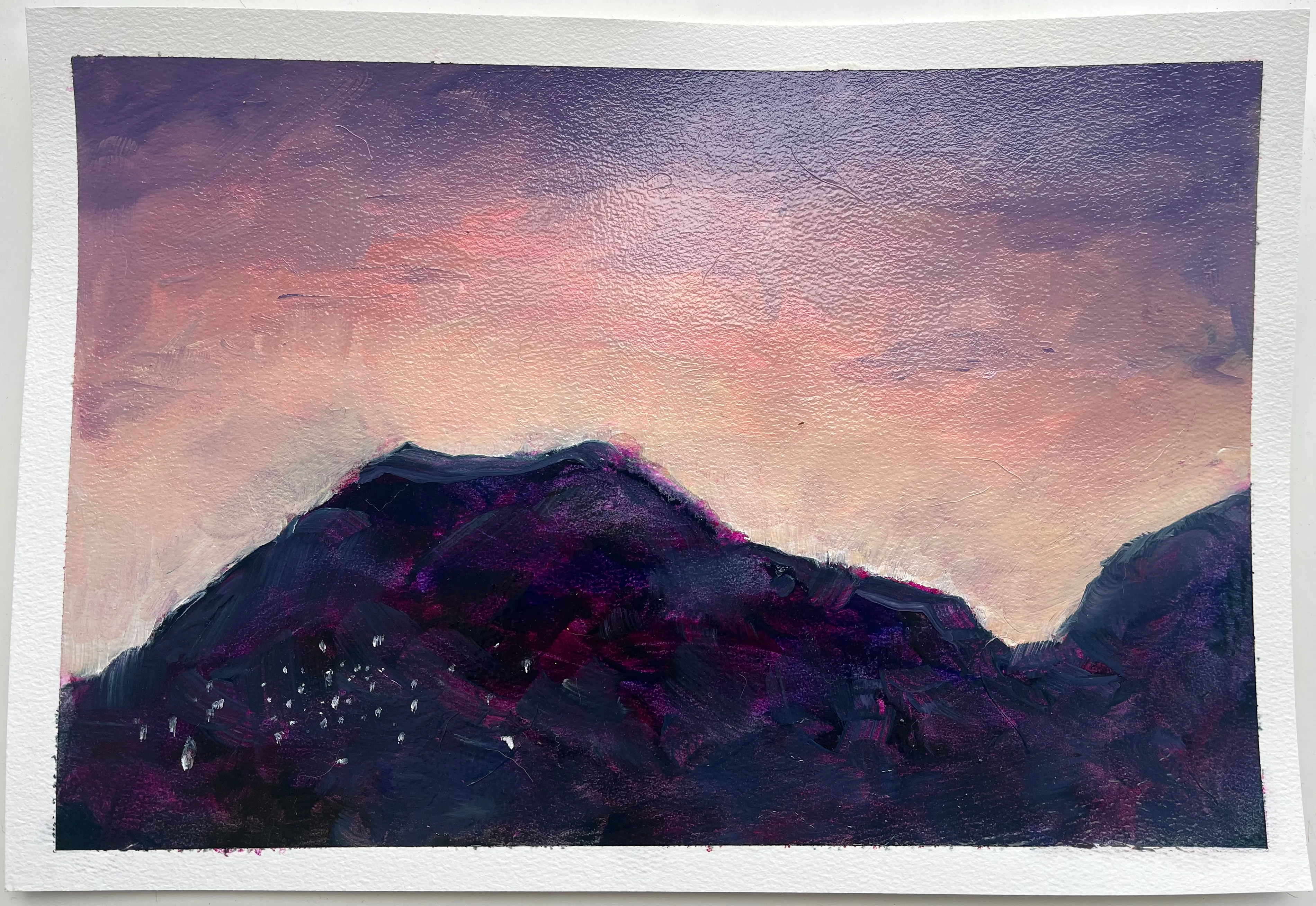Cerros violetas bajo un cielo rosado y durazno, con pequeñas marcas claras en las laderas.