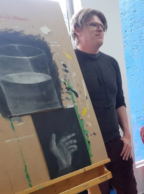 Victor Baumann junto a un tablero de dibujo con dos estudios.